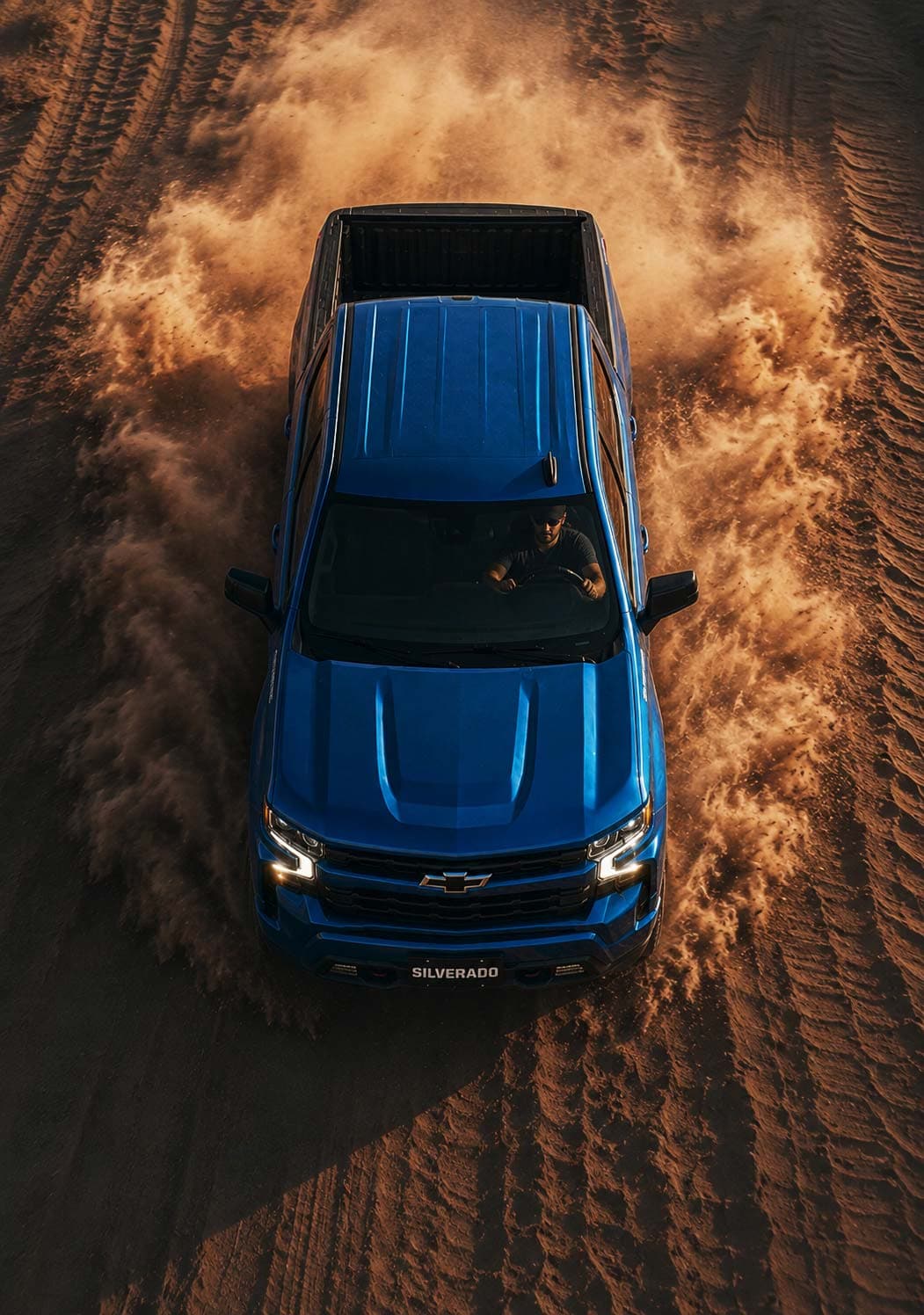 Chevrolet Silverado top-down dust trail view