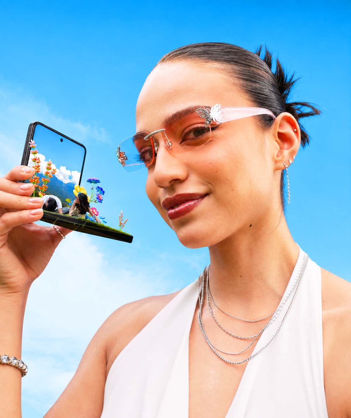 Model with futuristic sunglasses holding Galaxy Z Flip