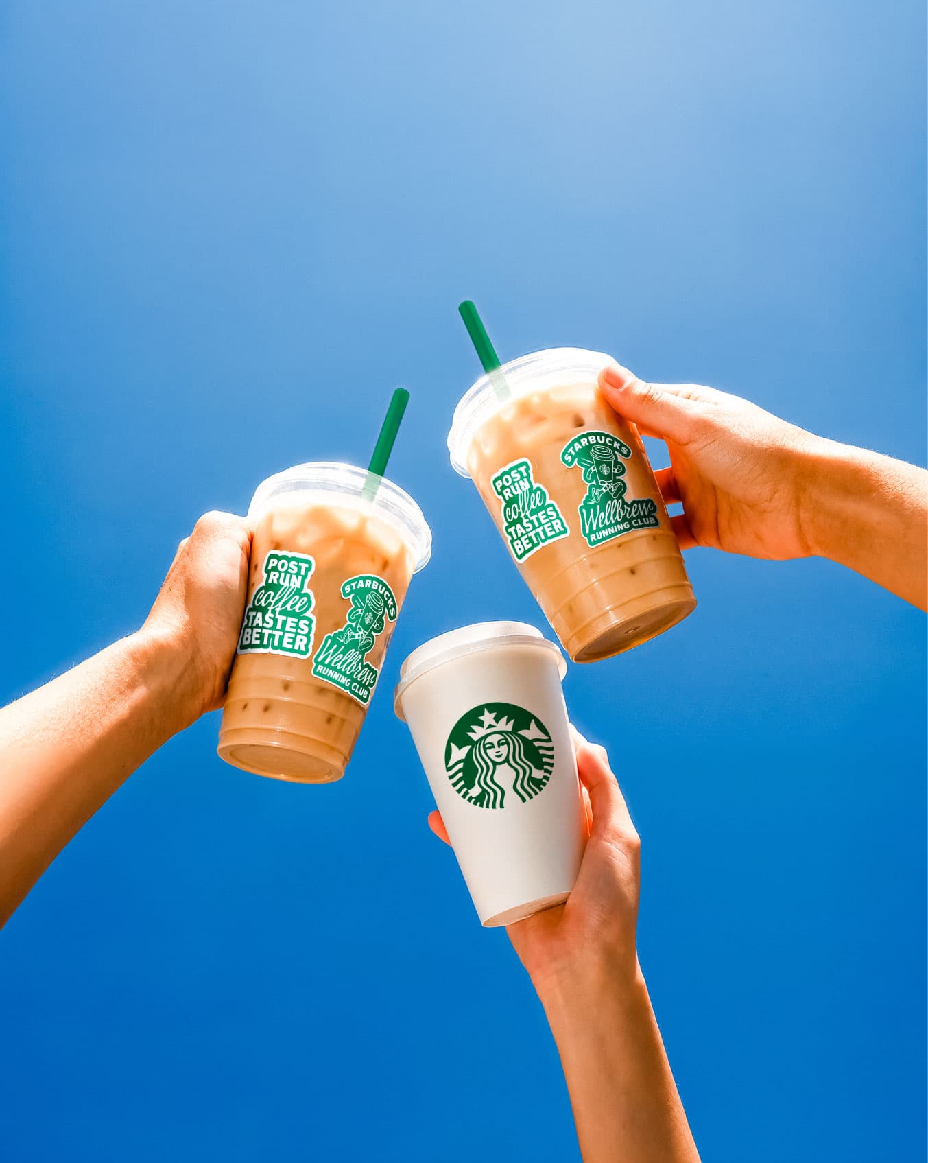 Hands toasting Starbucks iced beverage cups