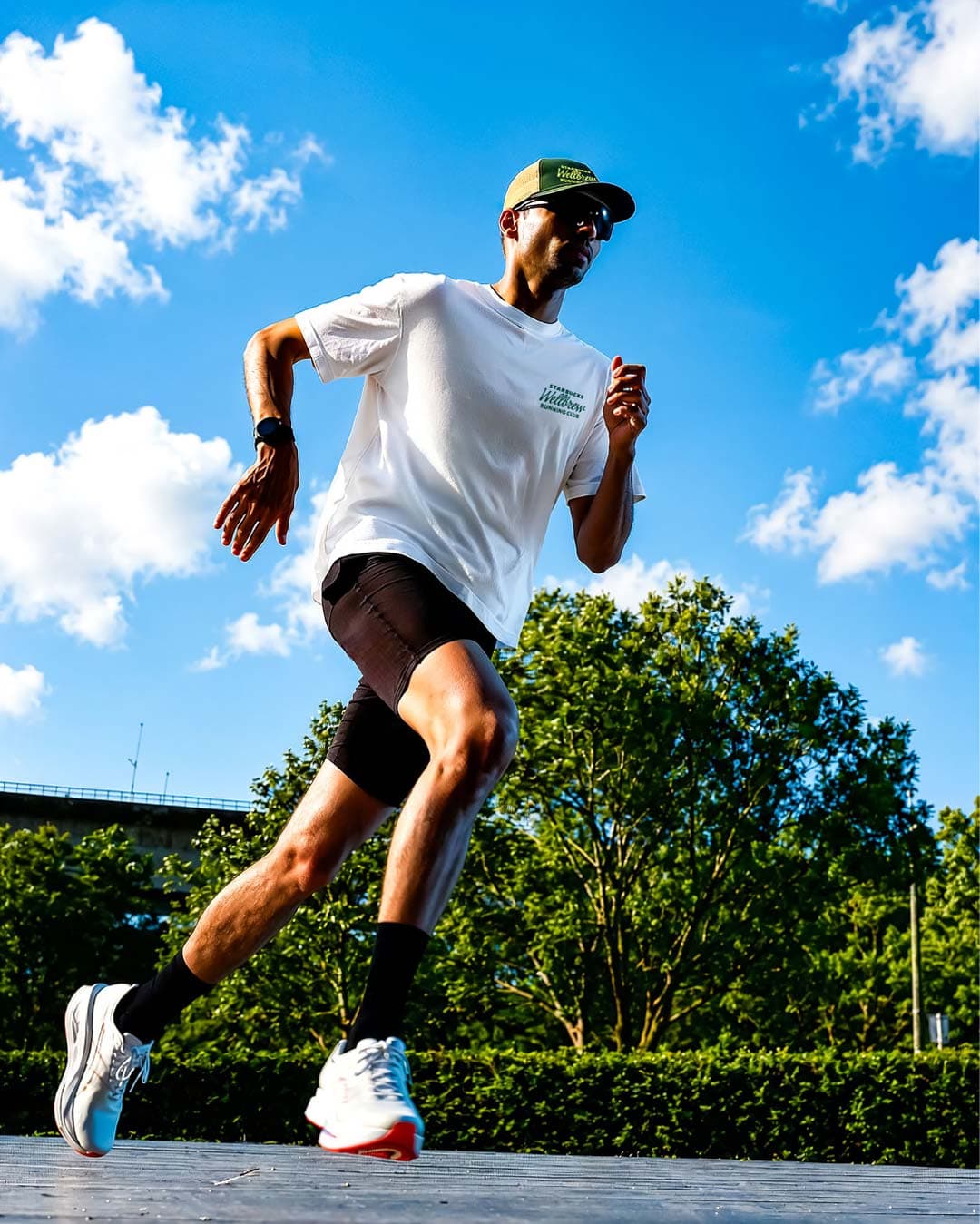 Male runner in white Starbucks tee in active motion