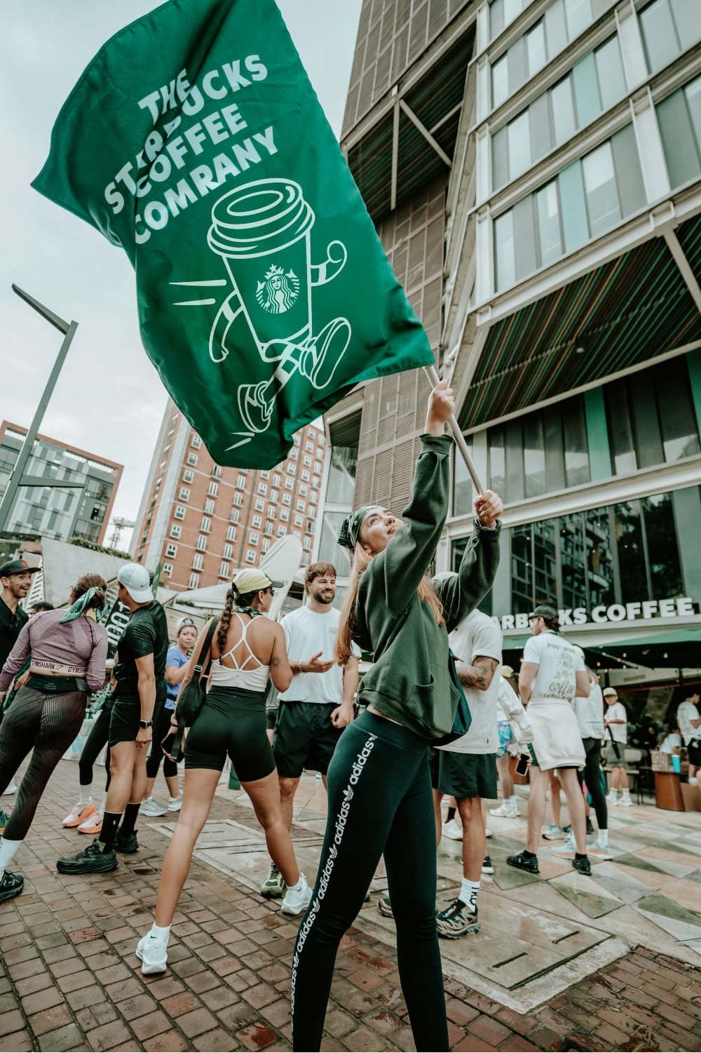 Runner waving green Starbucks Wellbrew flag