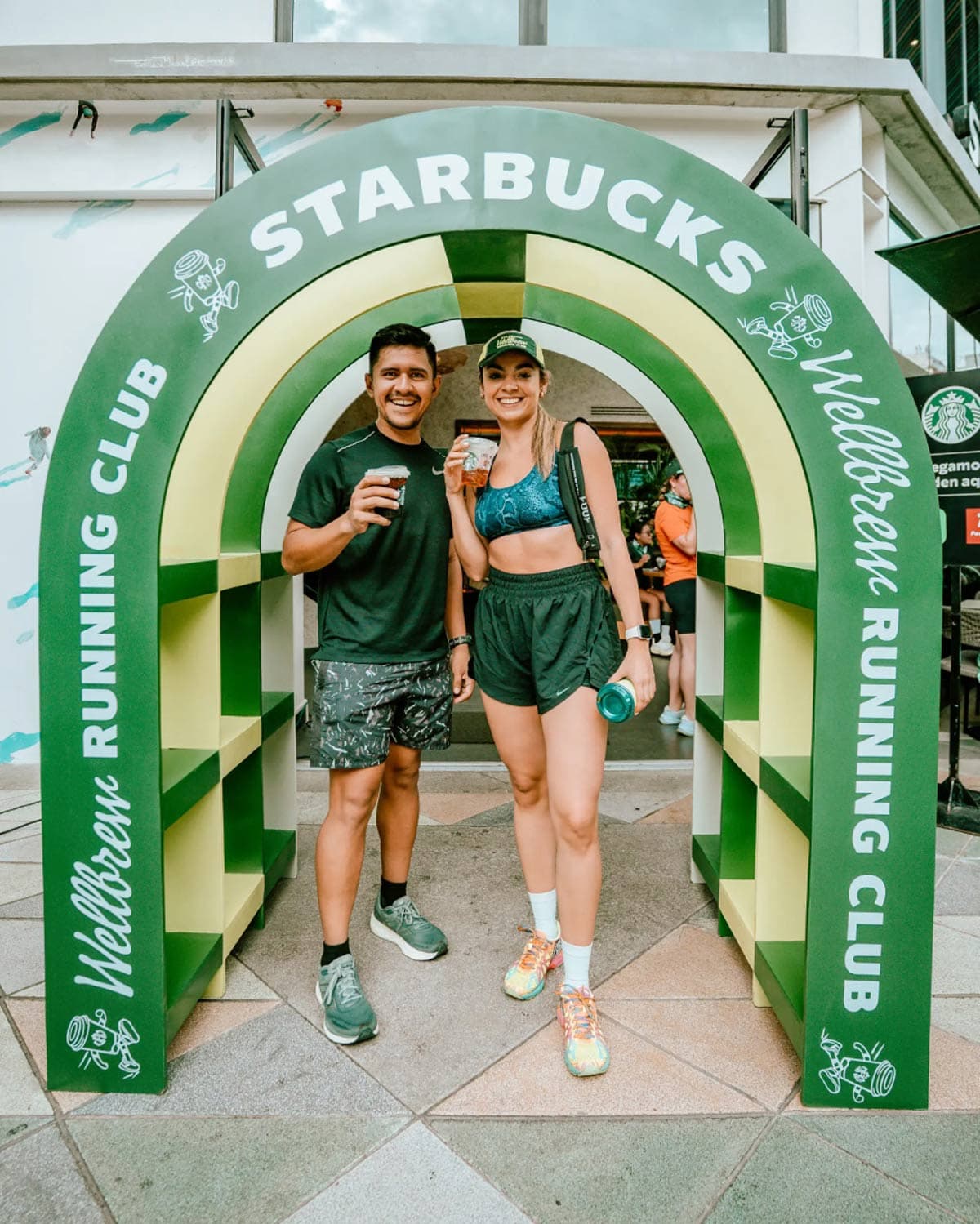 Runners posing together inside green brand archway