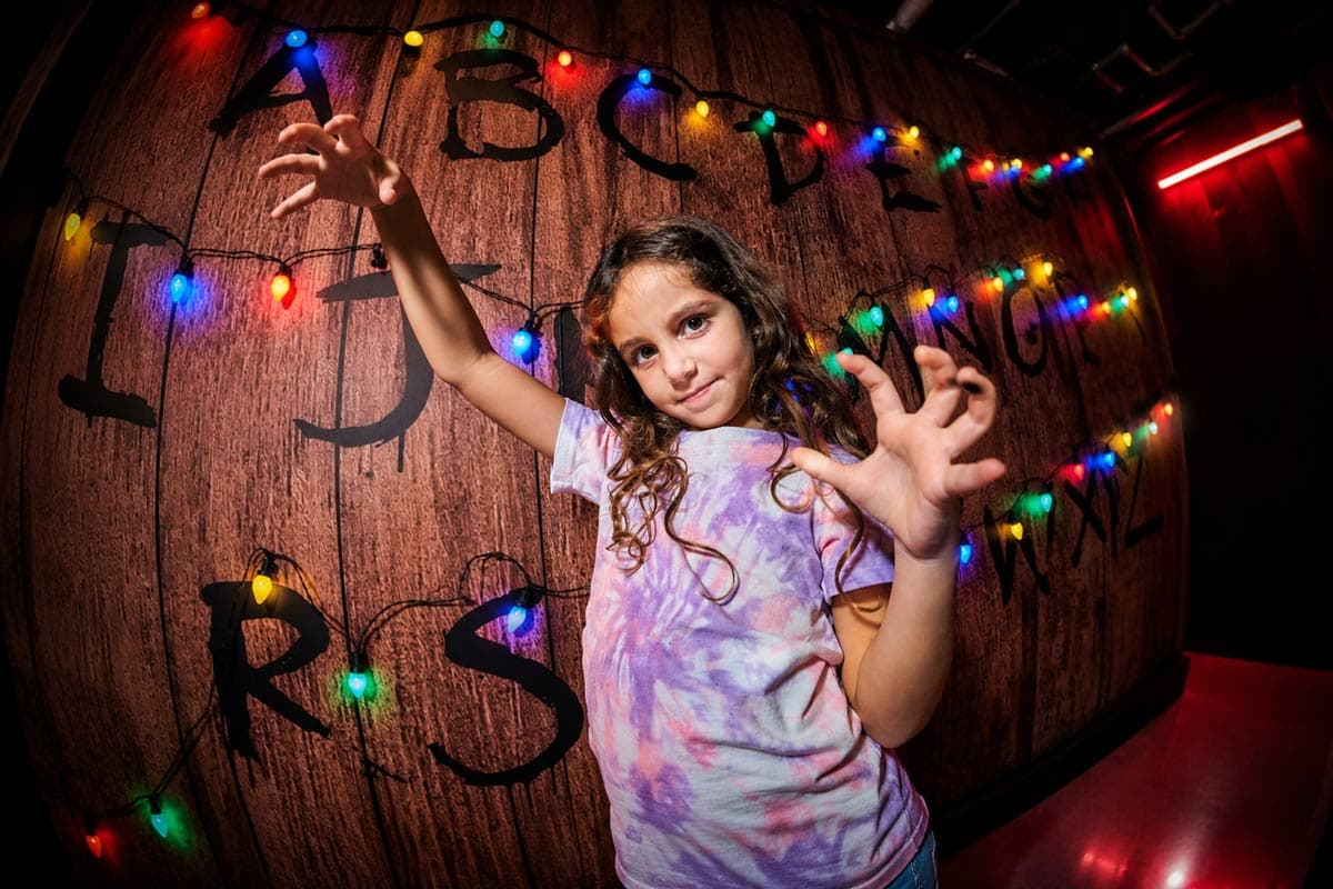 Girl interacting with the fairy lights alphabet wall