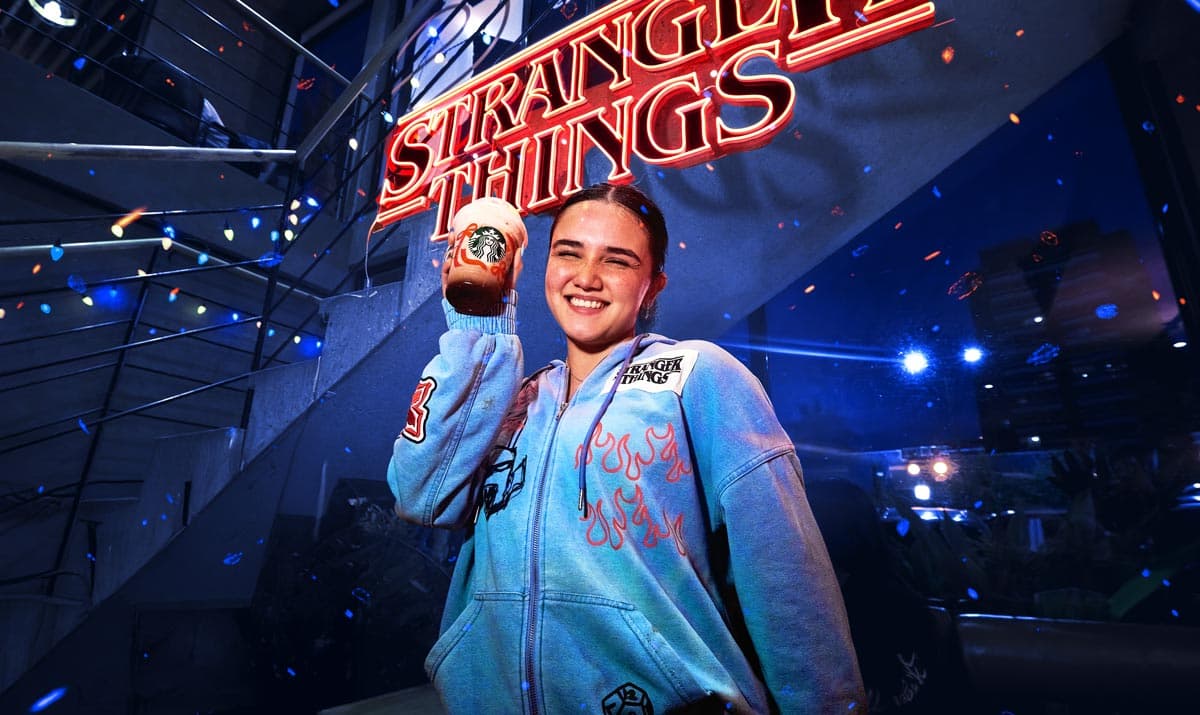 Guest posing beneath glowing Stranger Things logo