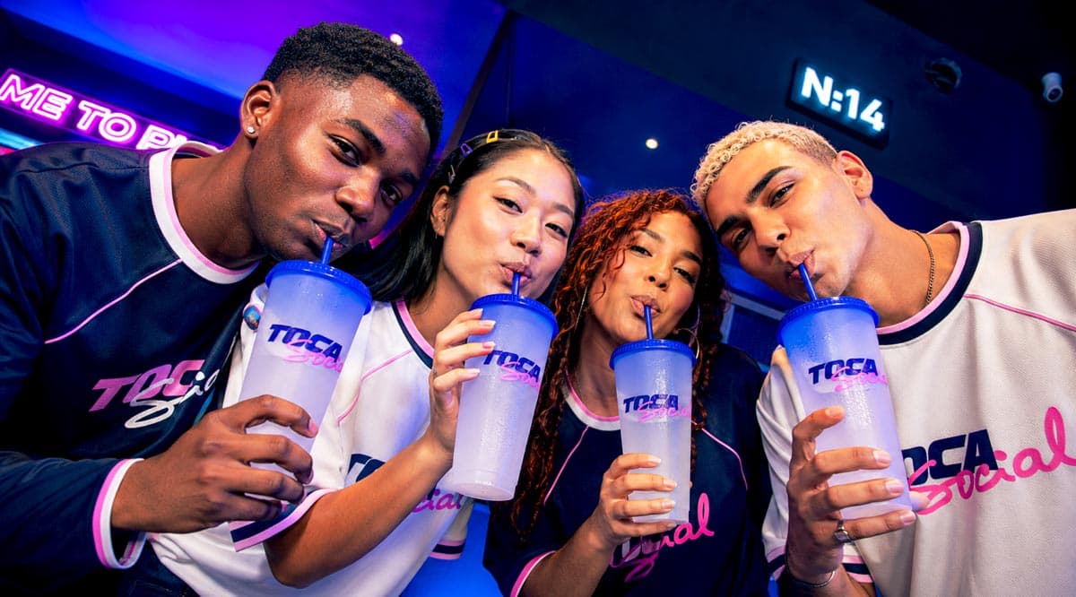 Friends drinking from TOCA Social stadium cups