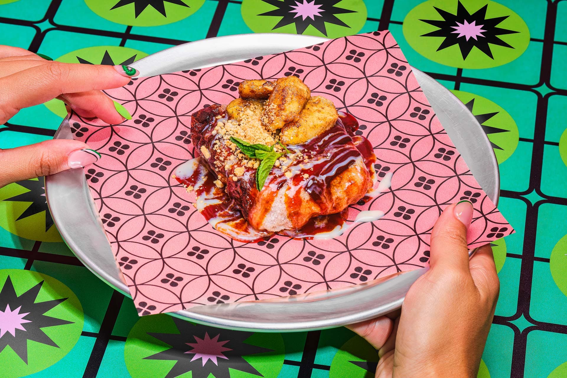 Dish served on pink patterned paper over green table